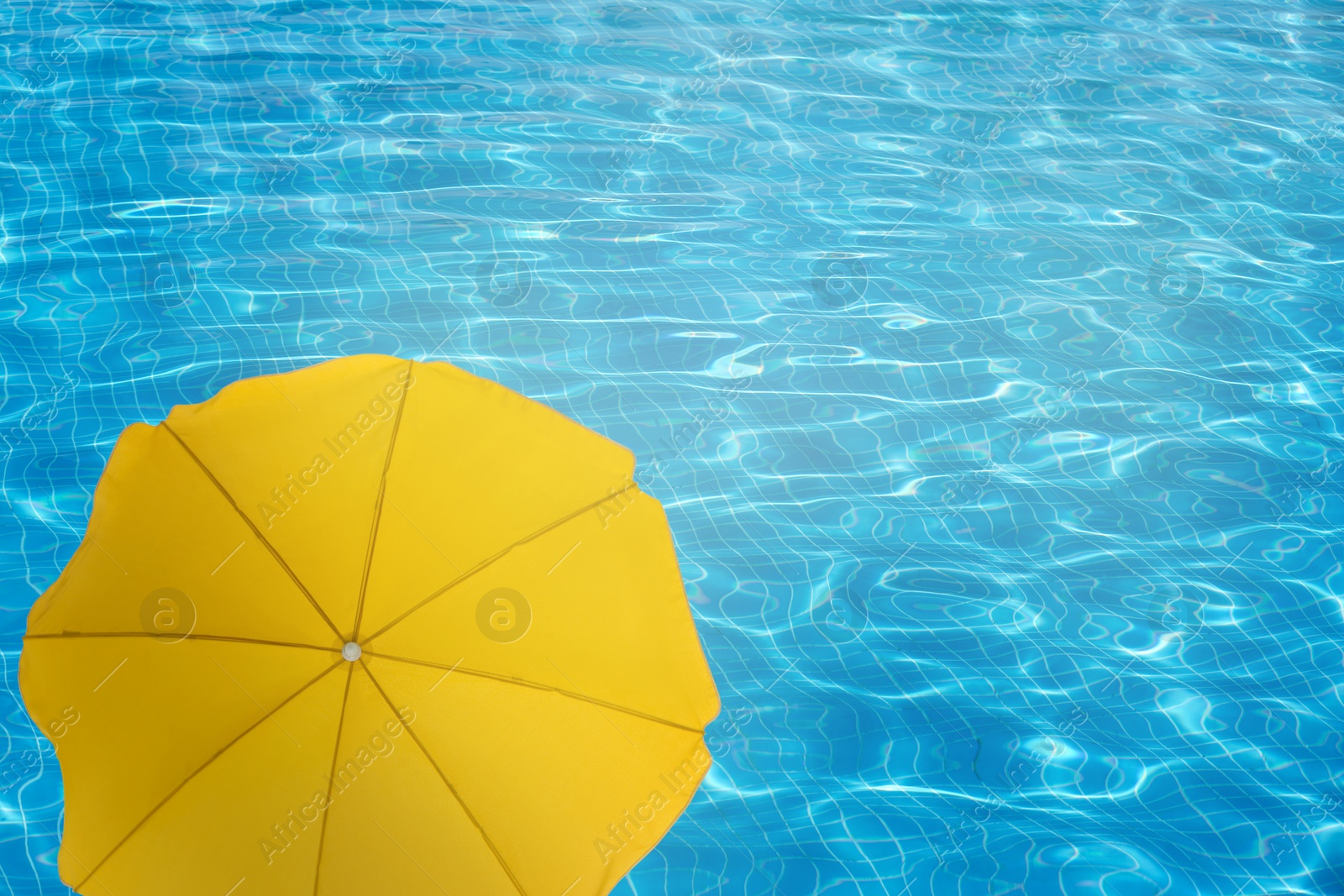 Image of Open beach umbrella and swimming pool. Summer vacation