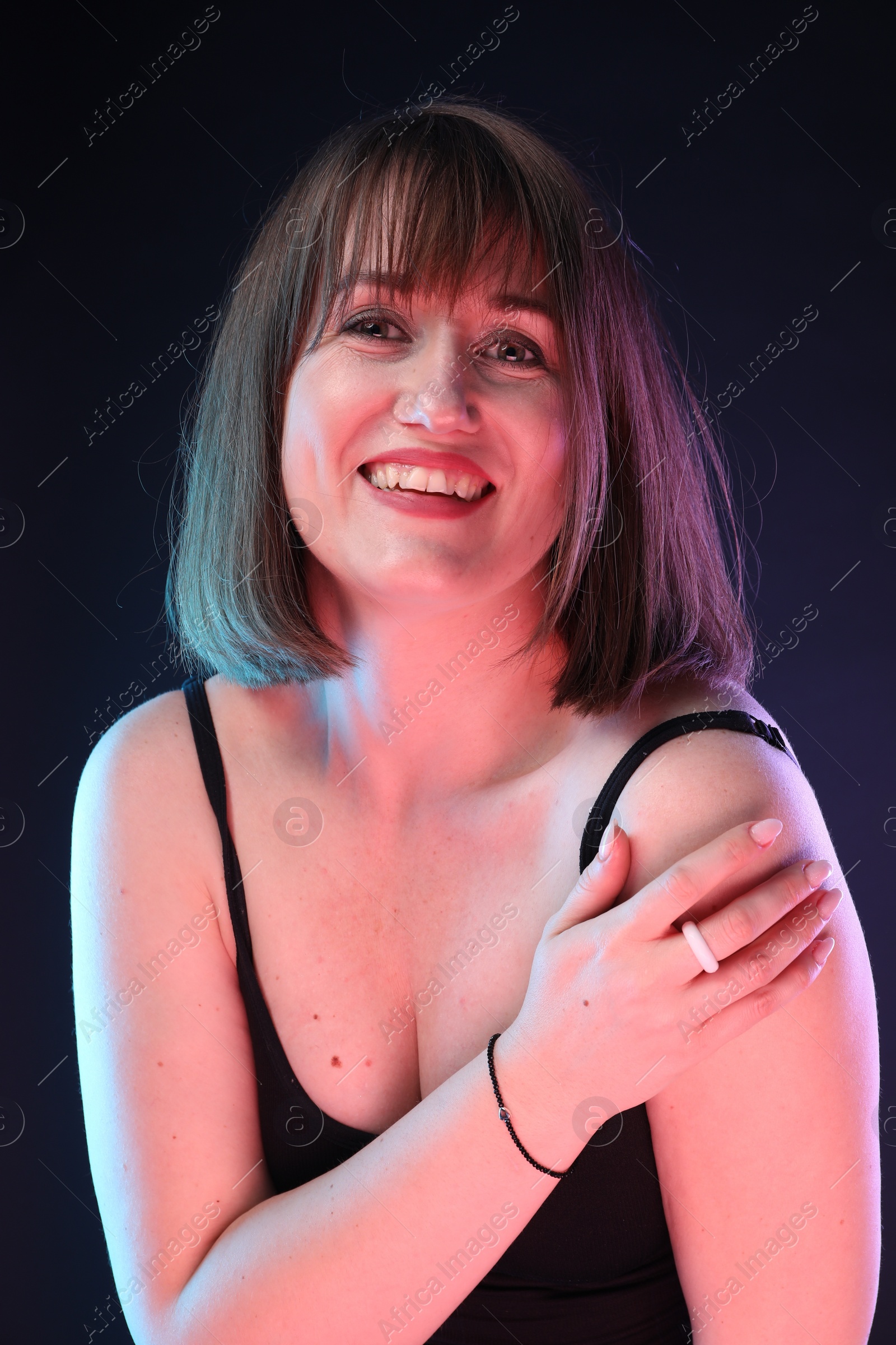 Photo of Portrait of happy woman on dark background