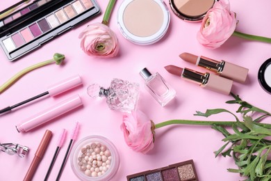 Flat lay composition with different makeup products and beautiful spring flowers on pink background