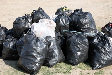 Photo of Many trash bags full of garbage outdoors. Environmental Pollution concept