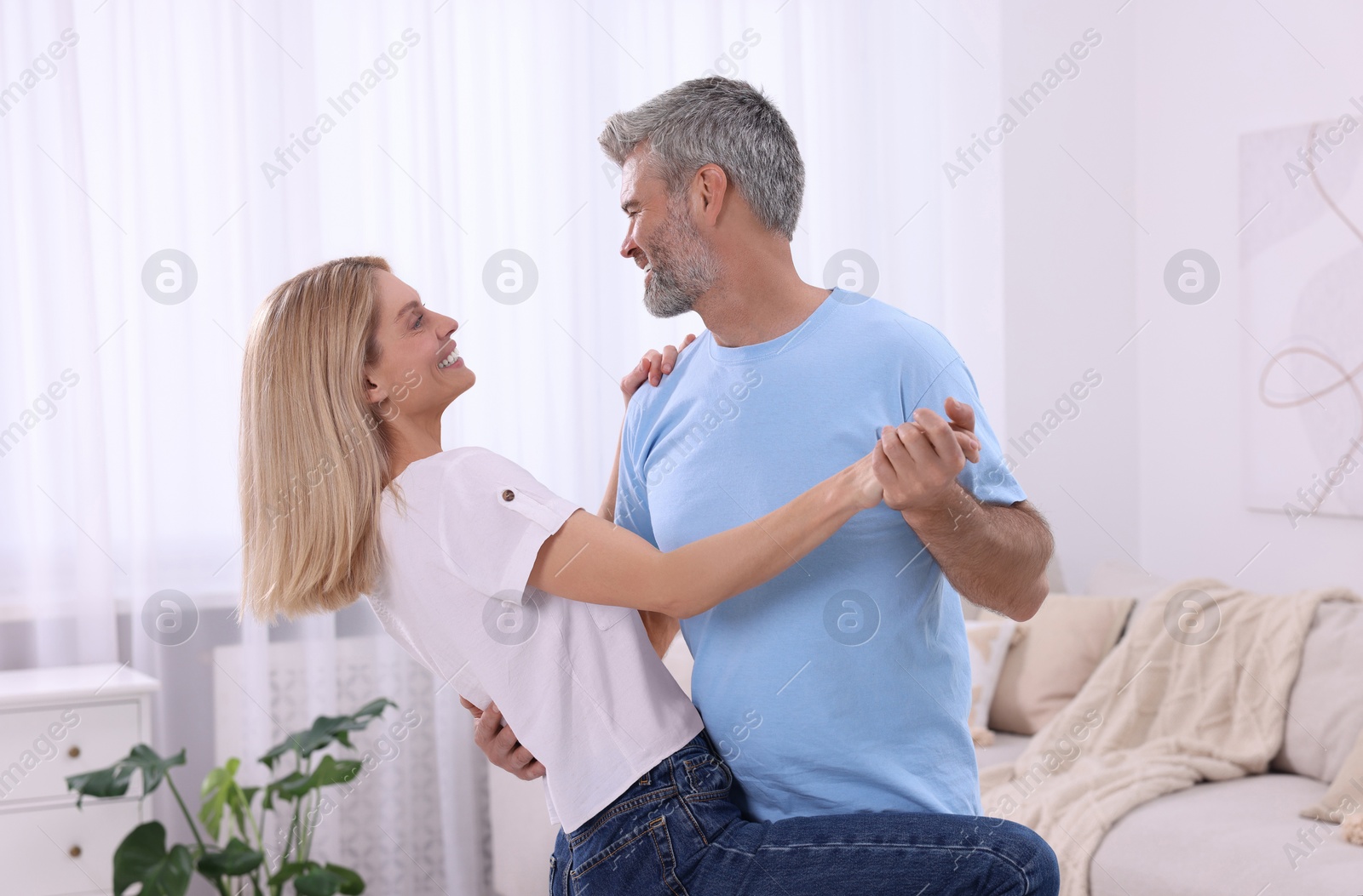 Photo of Happy affectionate couple dancing at home. Romantic date