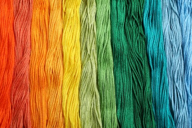 Photo of Different colorful embroidery threads as background, top view