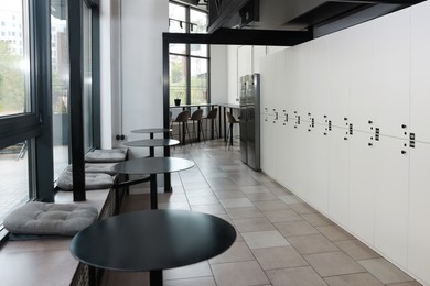 Photo of Hostel dining room interior with modern furniture and white lockers