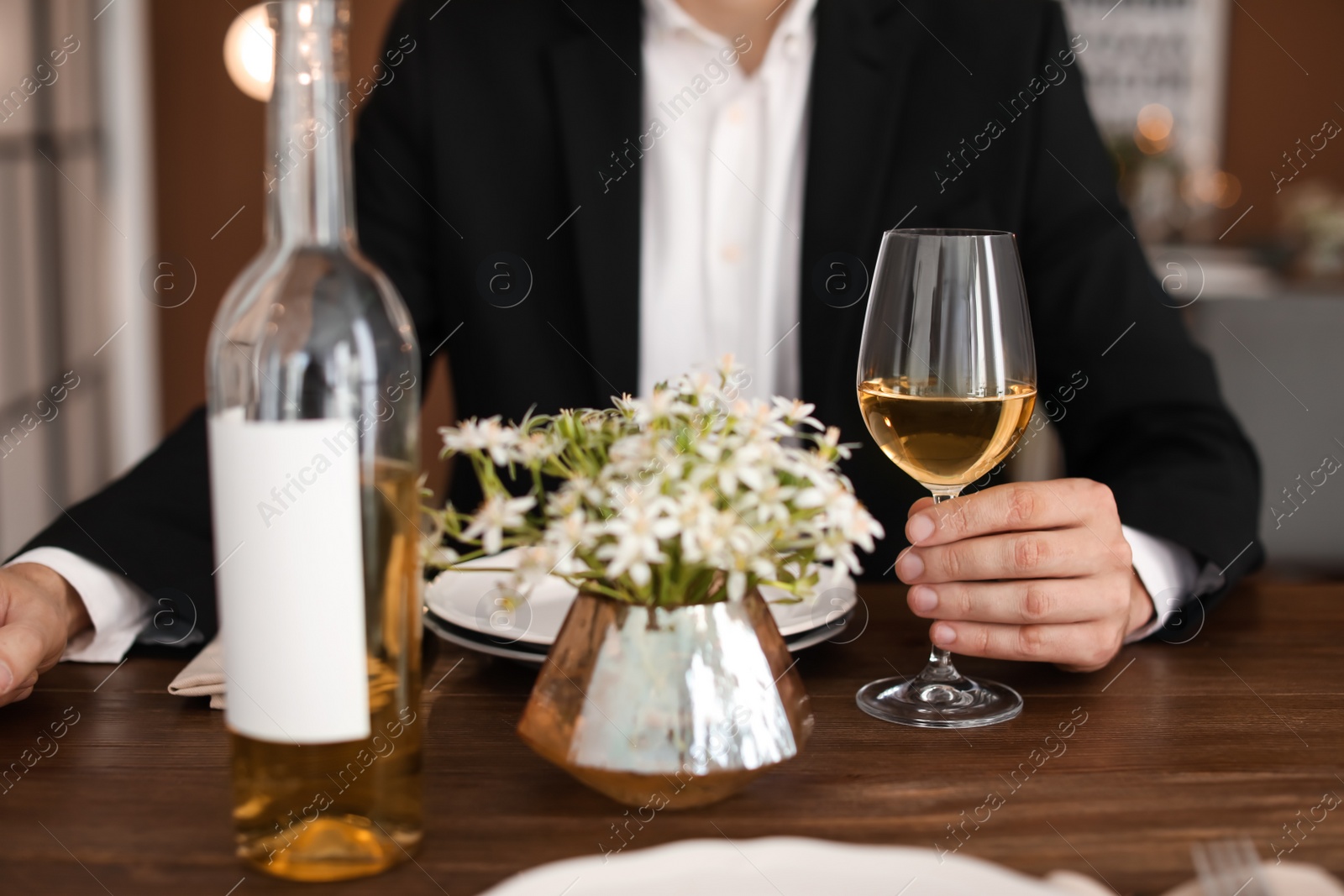 Photo of Man with glass of wine at table in restaurant