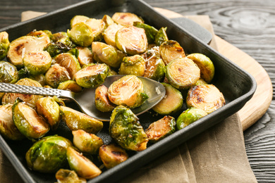 Photo of Delicious roasted brussels sprouts with grated cheese on table, closeup