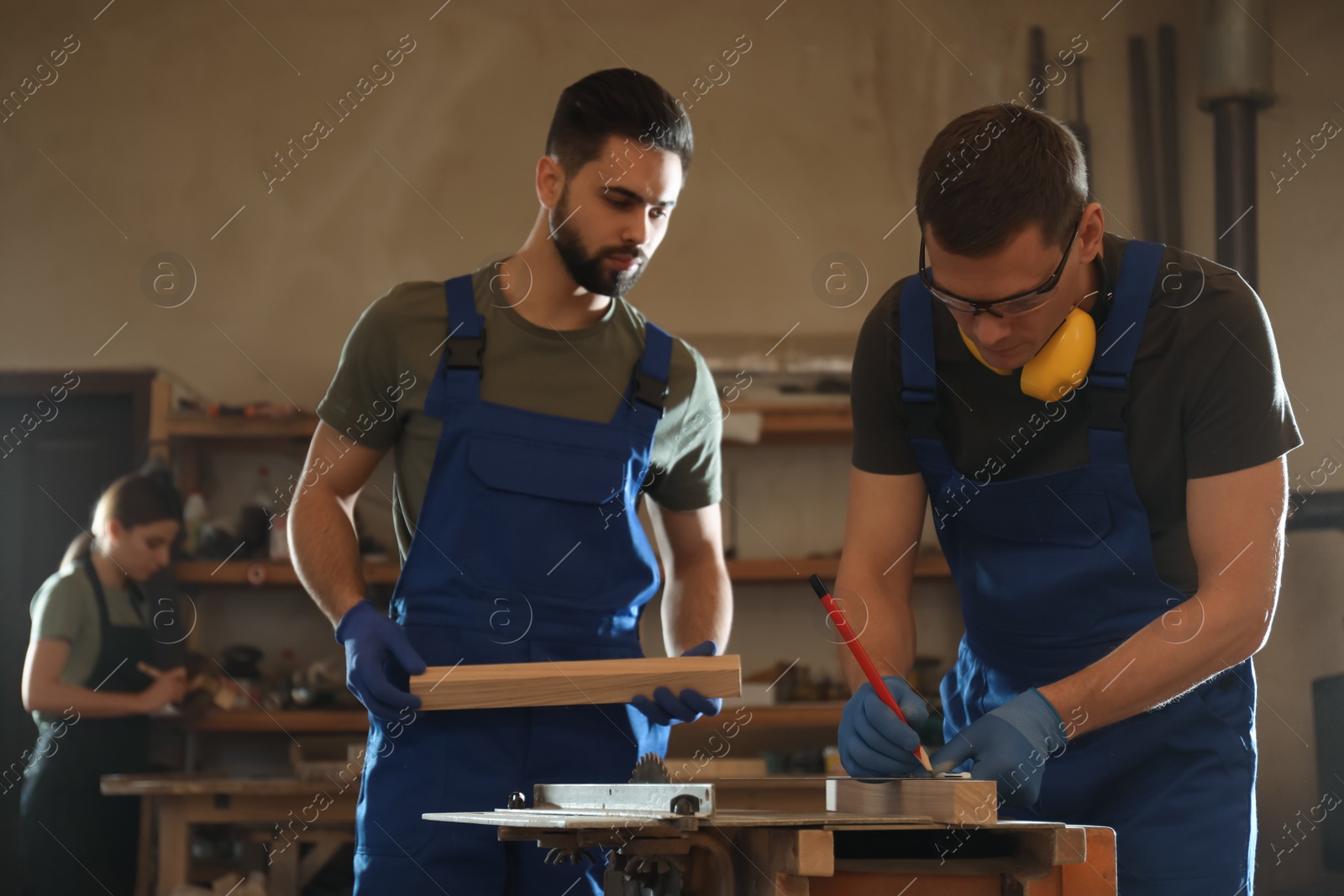 Photo of Professional carpenters working with wood in shop