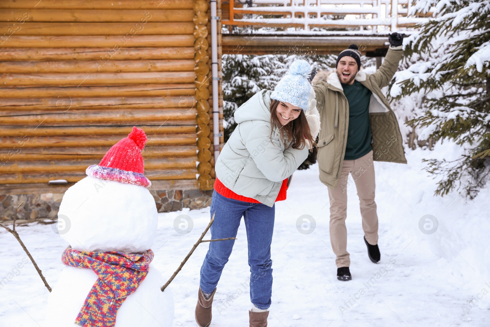 Photo of Happy couple playing snowballs outdoors. Winter vacation