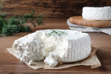 Photo of Delicious cottage cheese with dill on wooden table