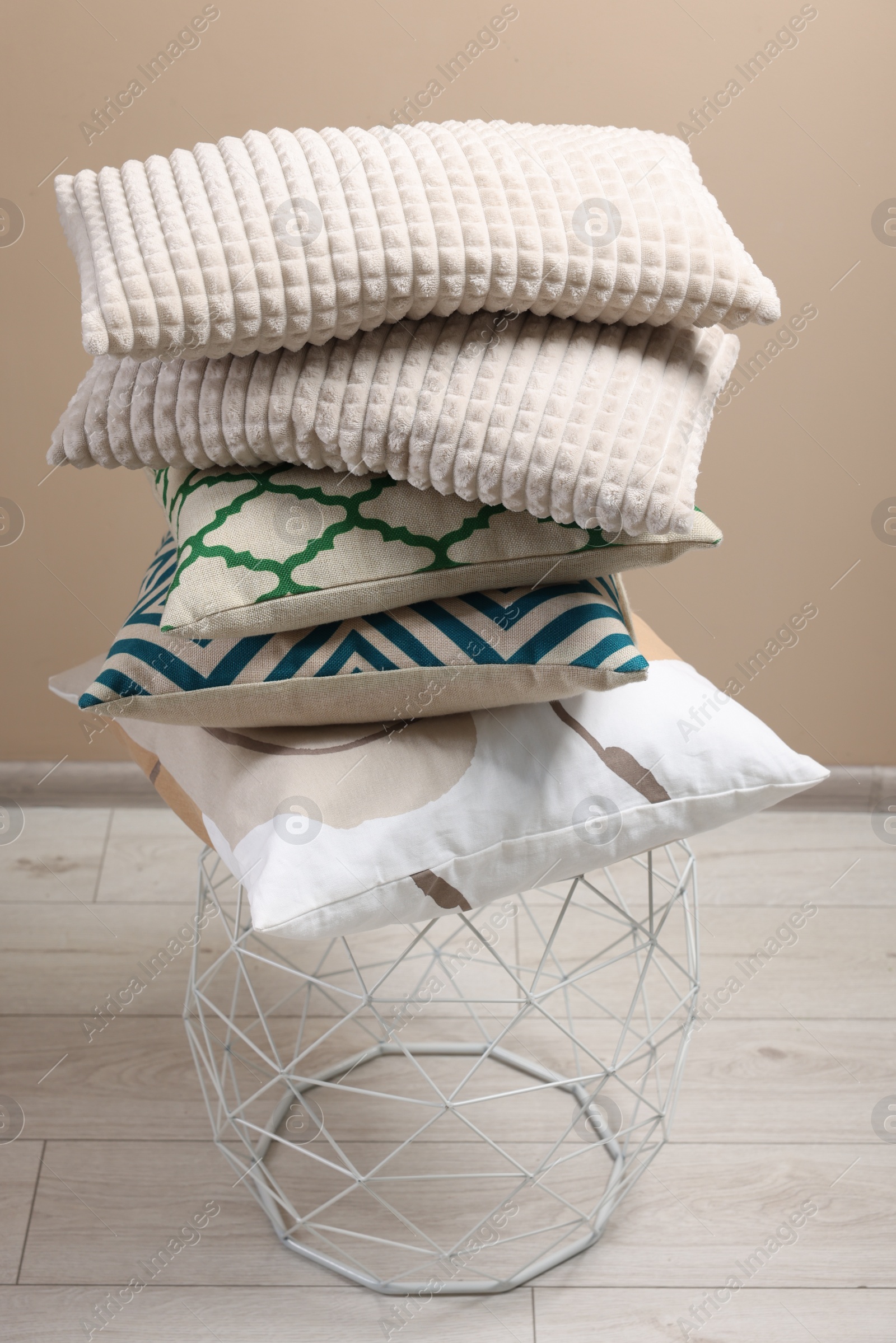 Photo of Stack of soft pillows on small table indoors