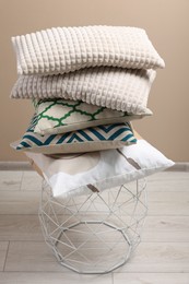 Stack of soft pillows on small table indoors