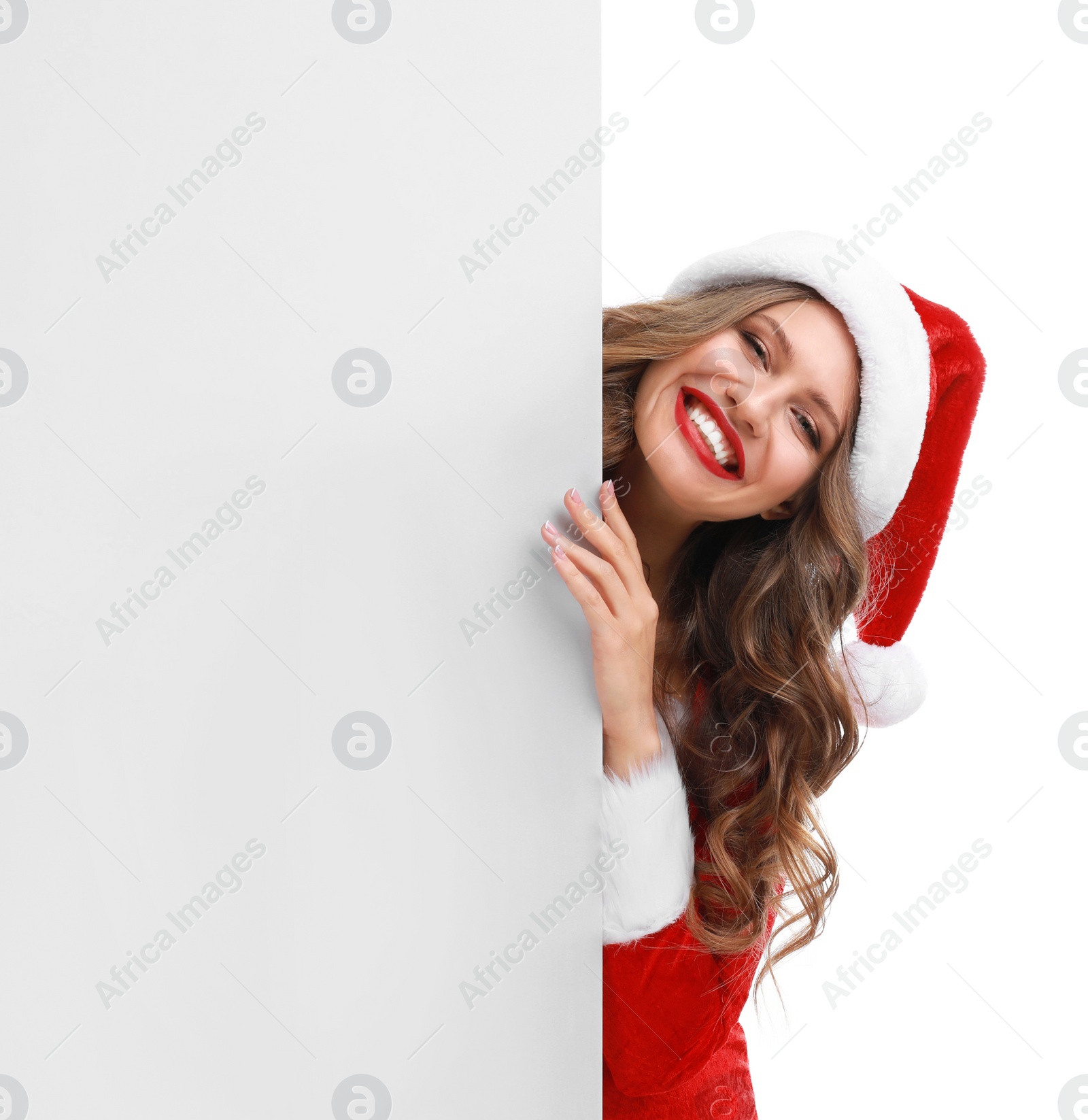 Photo of Beautiful Santa girl peeping out of blank banner on white background. Christmas celebration