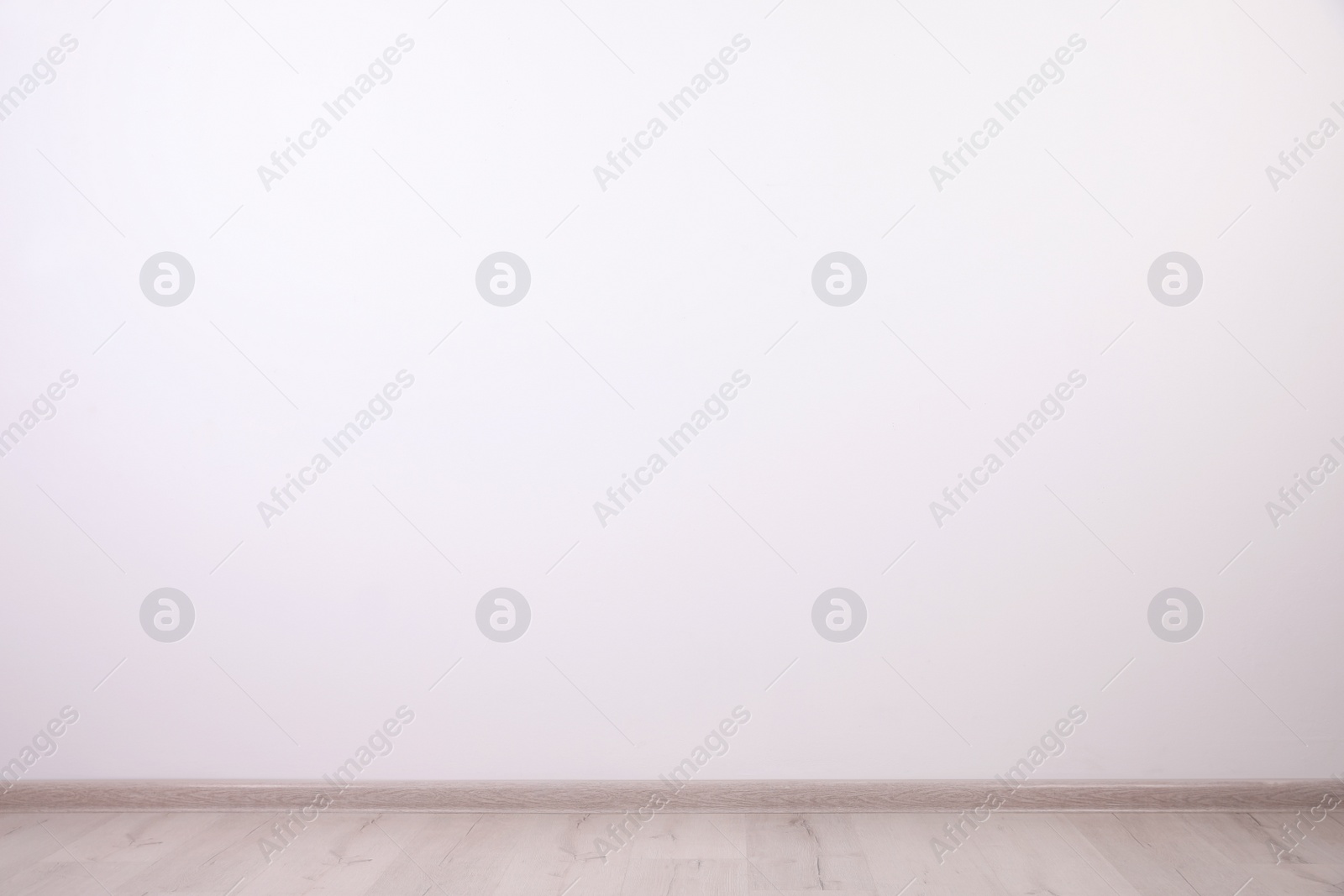 Photo of Empty room with white wall and wooden floor