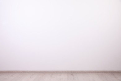 Empty room with white wall and wooden floor