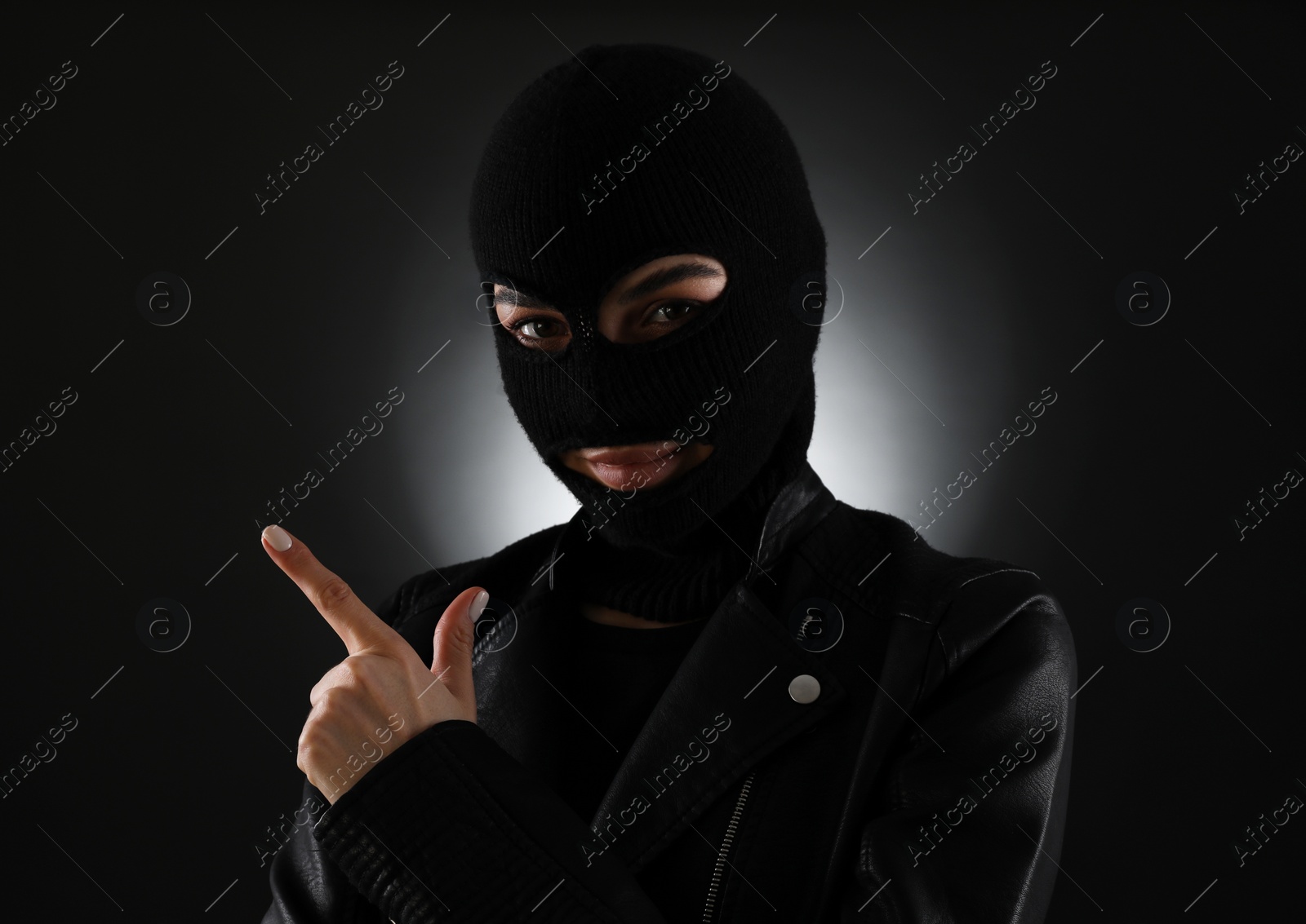 Photo of Woman wearing knitted balaclava on black background