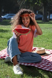 Photo of Beautiful young African American woman with slice of watermelon in park