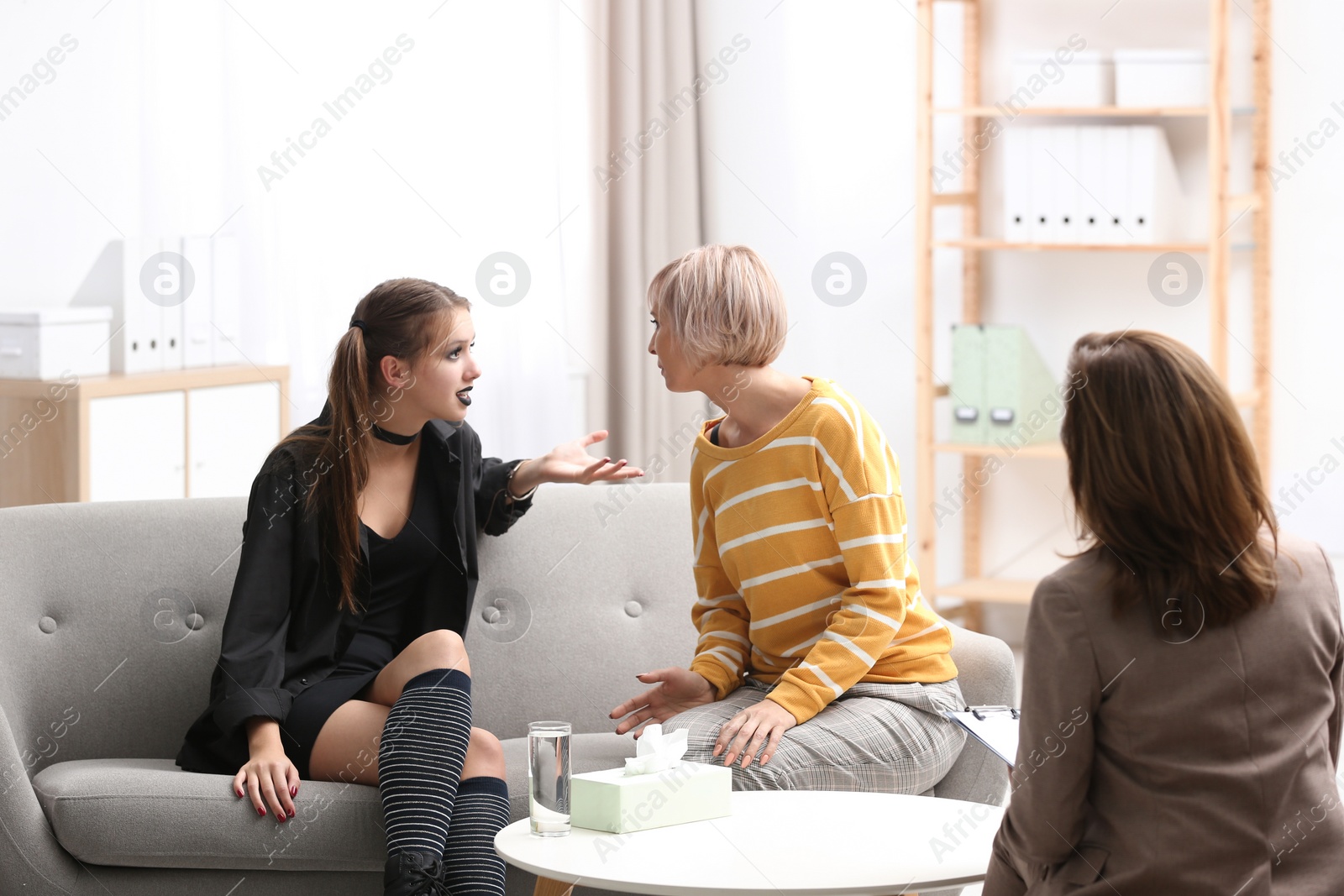 Photo of Psychotherapist working with teenage goth girl and her mother in office