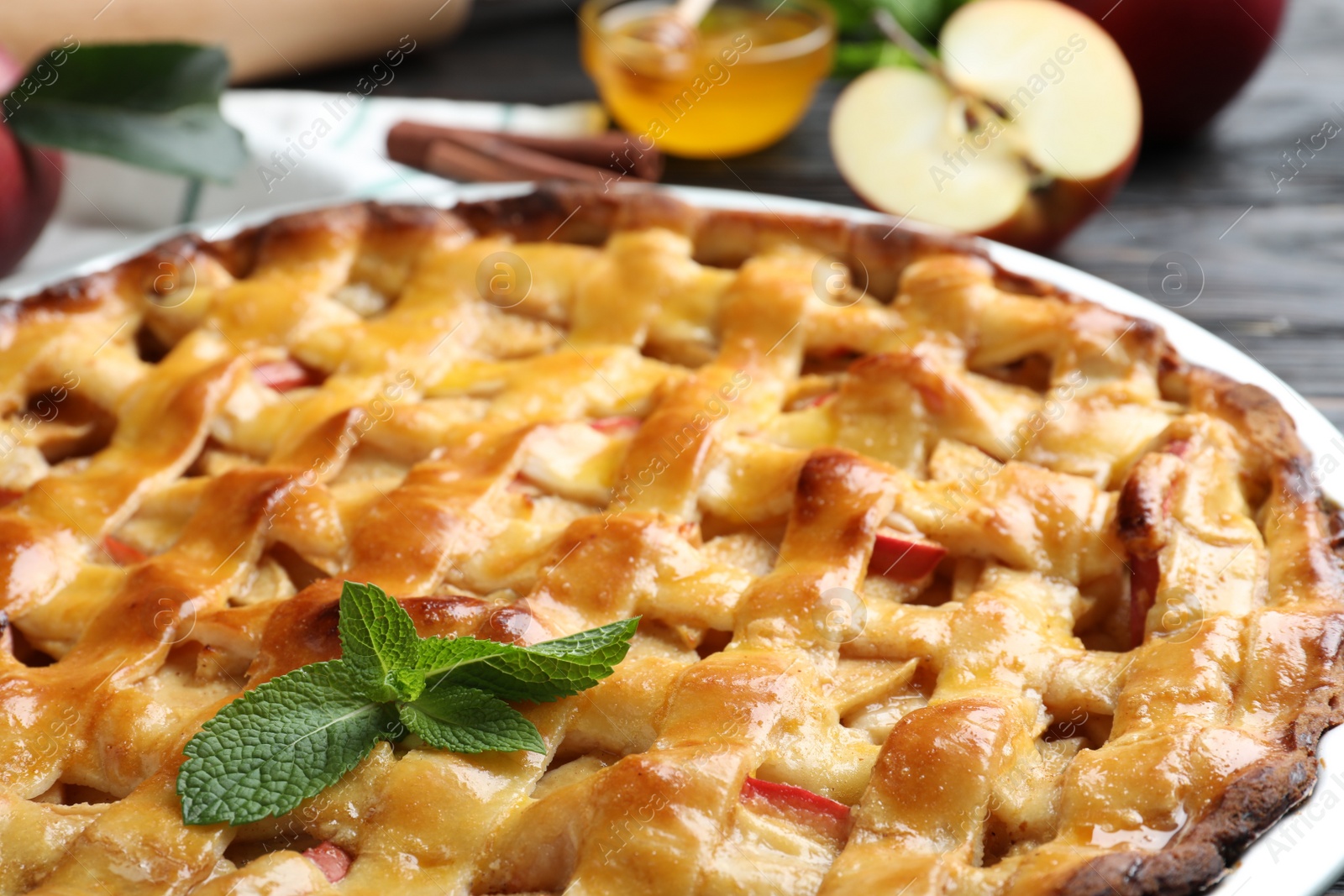 Photo of Traditional apple pie with mint on table, closeup