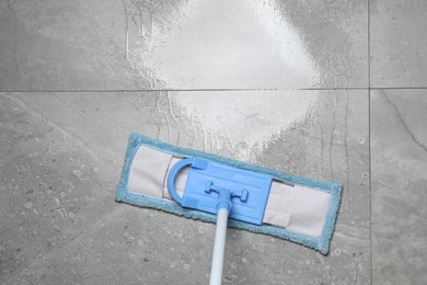 Photo of Cleaning grey marble floor with mop indoors, top view. Space for text