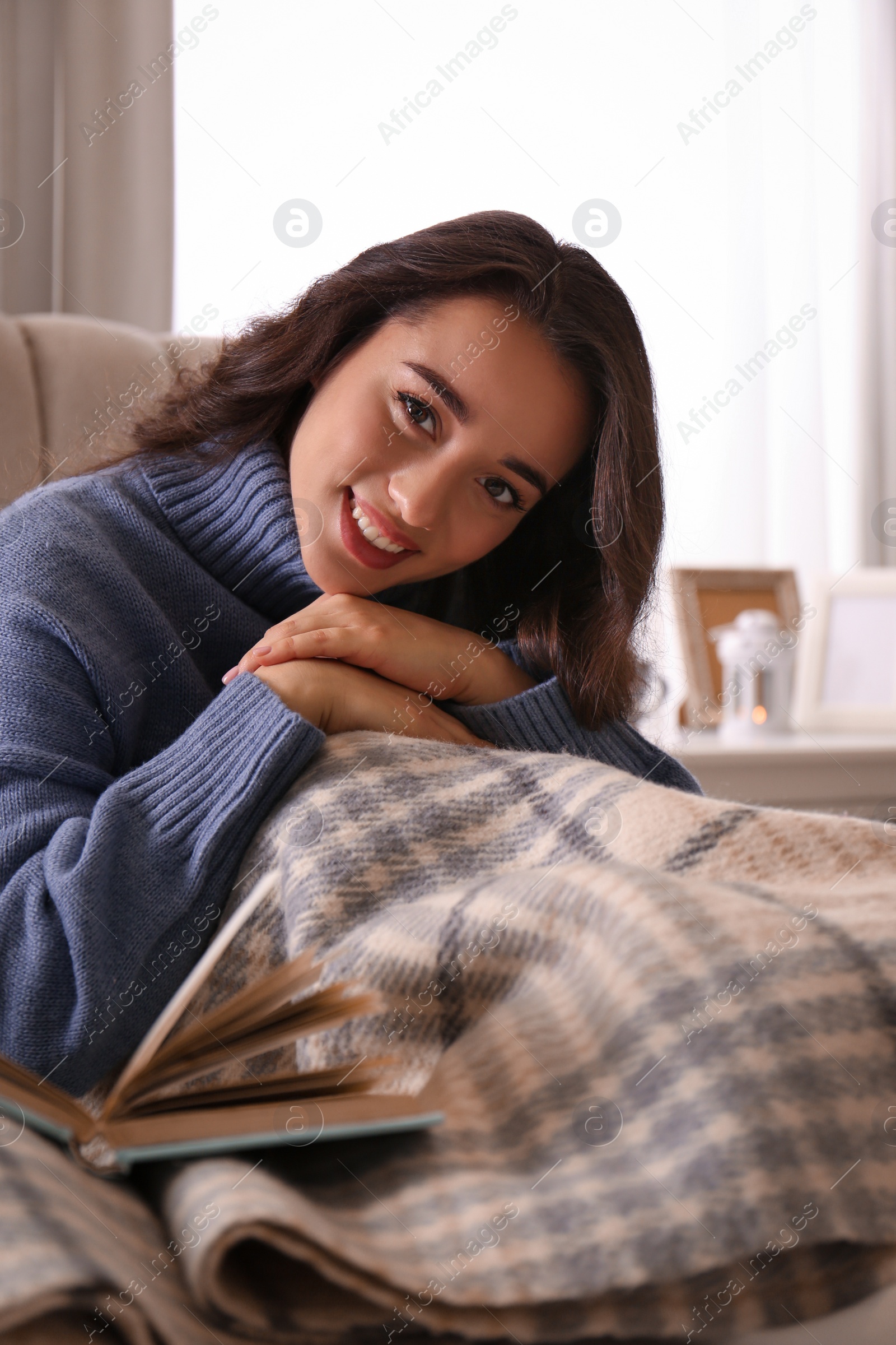 Photo of Young woman in knitted sweater resting at home. Winter atmosphere