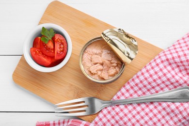 Photo of Can of conserved tuna and tomatoes on white wooden table, top view