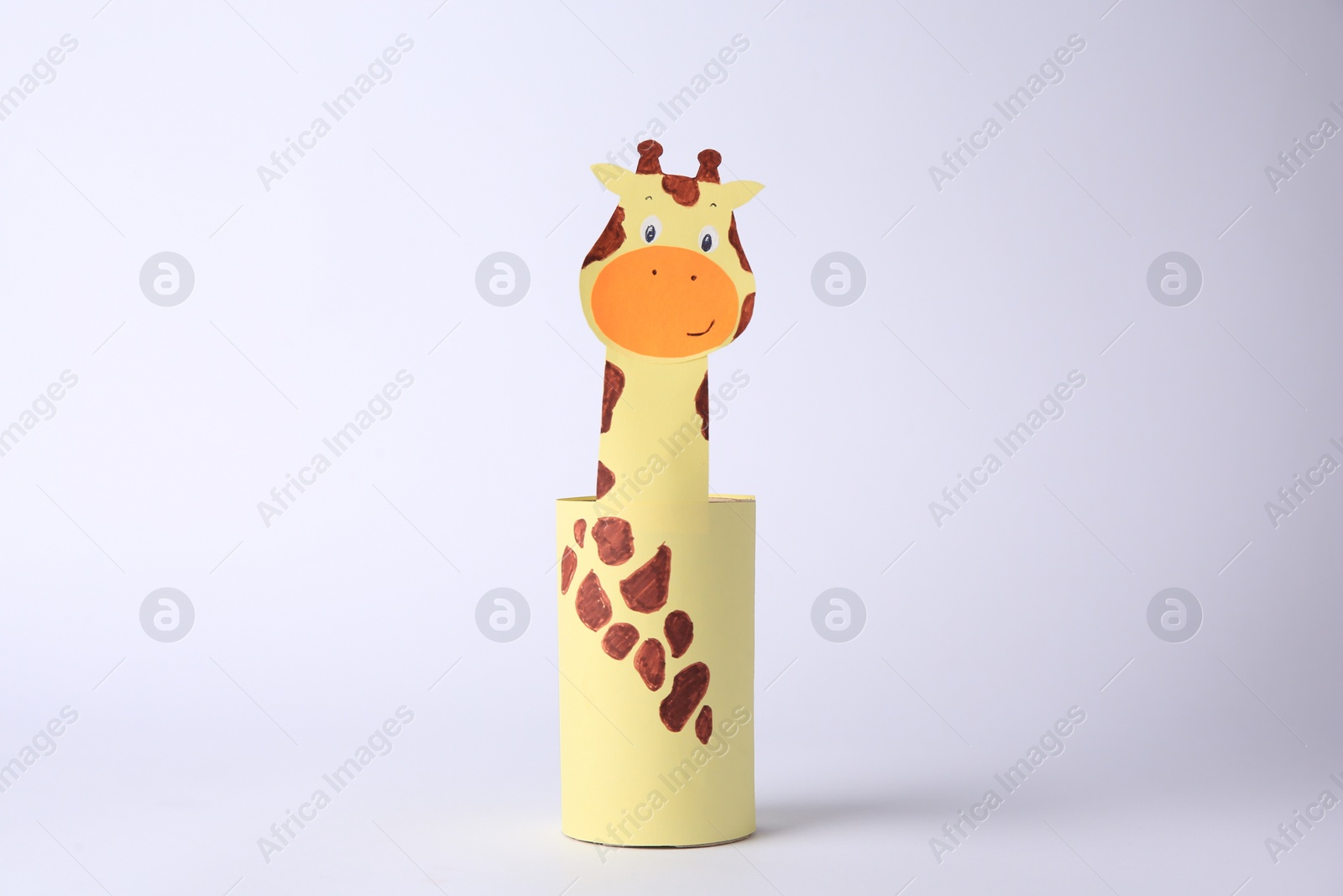 Photo of Toy giraffe made from toilet paper hub on white background. Children's handmade ideas