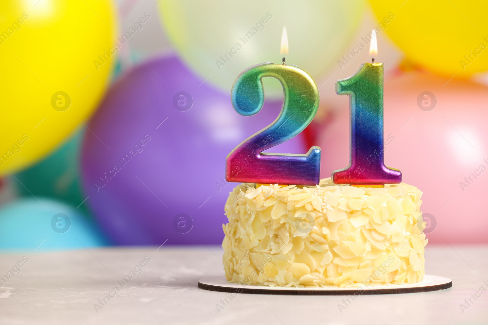 Photo of Coming of age party - 21st birthday. Delicious cake with number shaped candles on light grey table near balloons, space for text