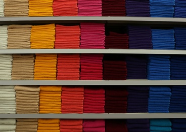 Stacks of colourful towels on store shelves