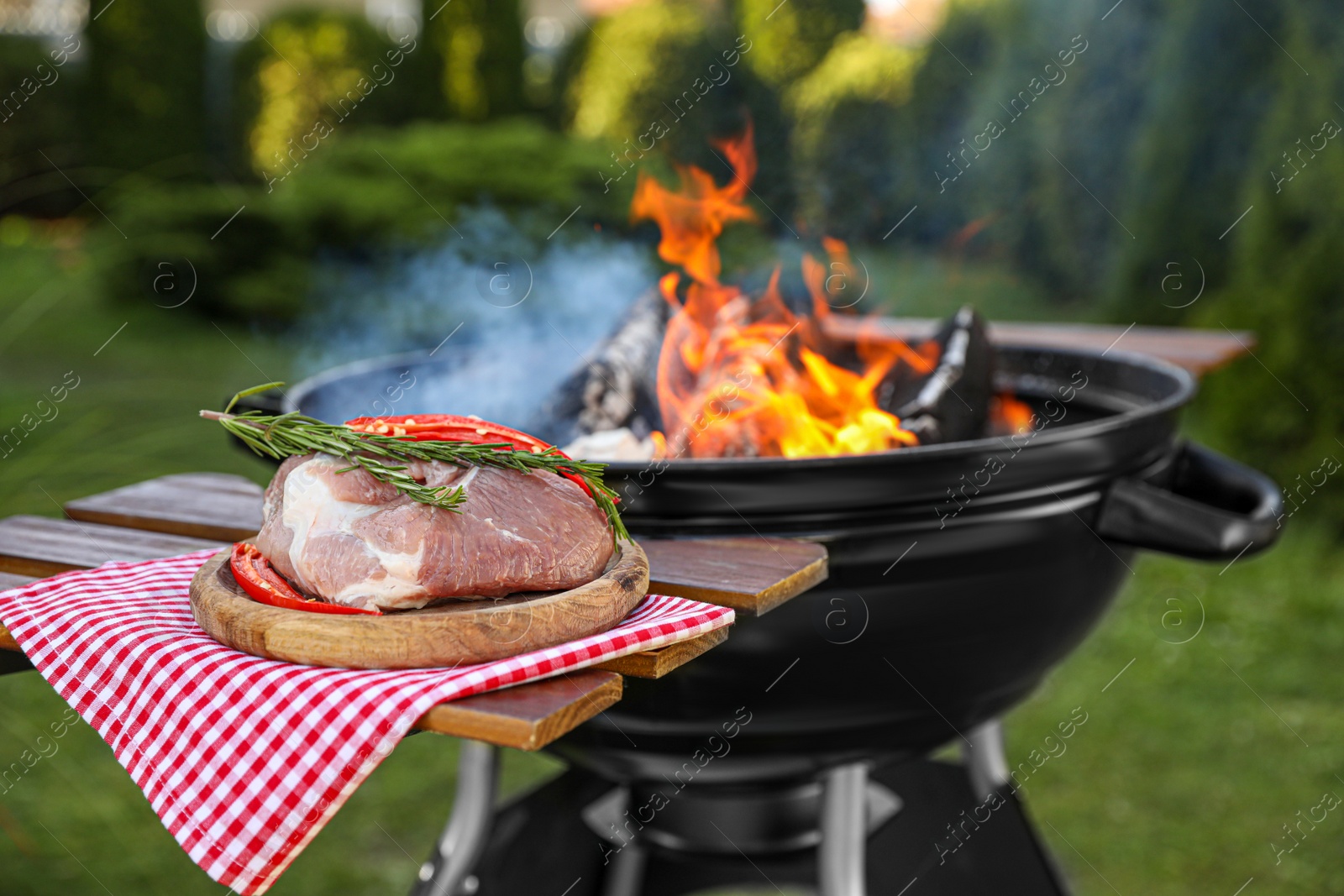 Photo of Raw meat on table near barbecue grill outdoors