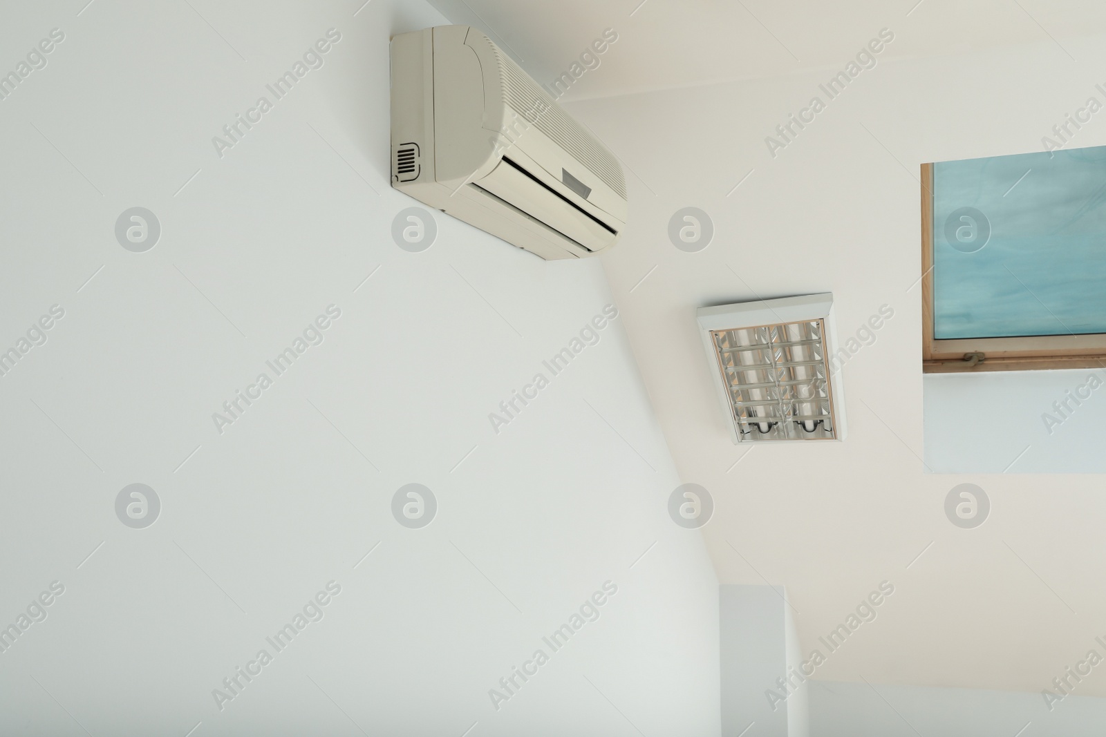 Photo of Modern air conditioner on white wall indoors