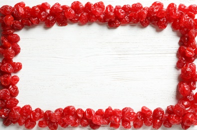 Frame of cherries on wooden background, top view with space for text. Dried fruit as healthy snack