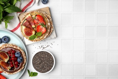 Photo of Tasty crispbreads with different toppings on light table, flat lay. Space for text