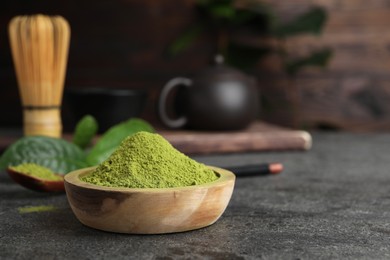 Photo of Green matcha powder on grey table, closeup. Space for text