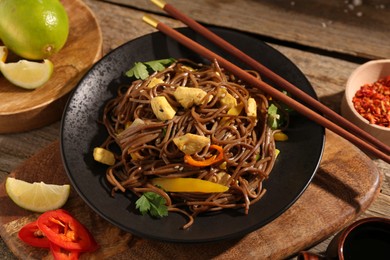 Photo of Stir-fry. Tasty noodles with vegetables and meat served on wooden table