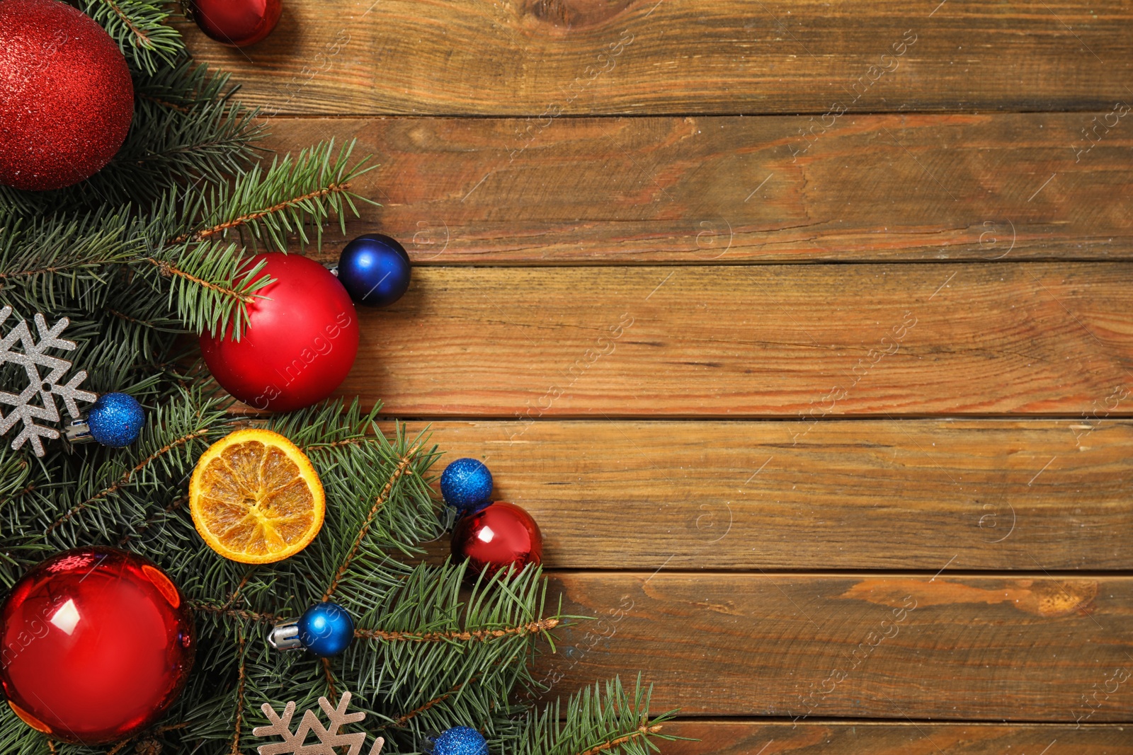 Photo of Fir branches with Christmas decoration on wooden background, flat lay. Space for text