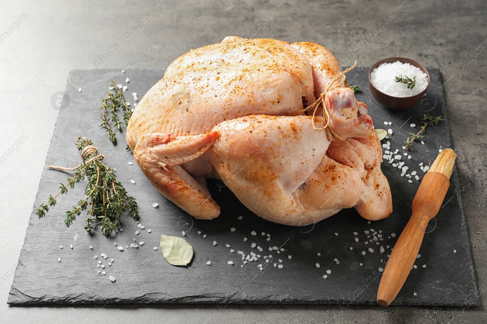 Photo of Slate plate with raw spiced turkey on table