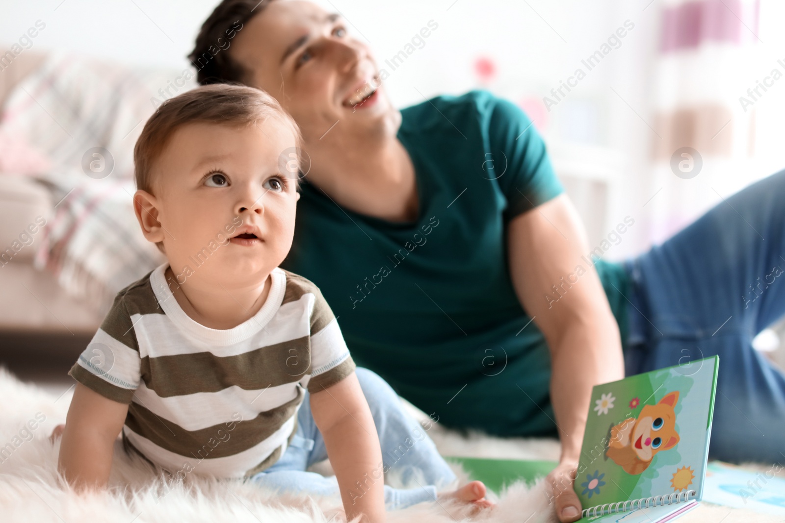 Photo of Young father with his cute little son at home