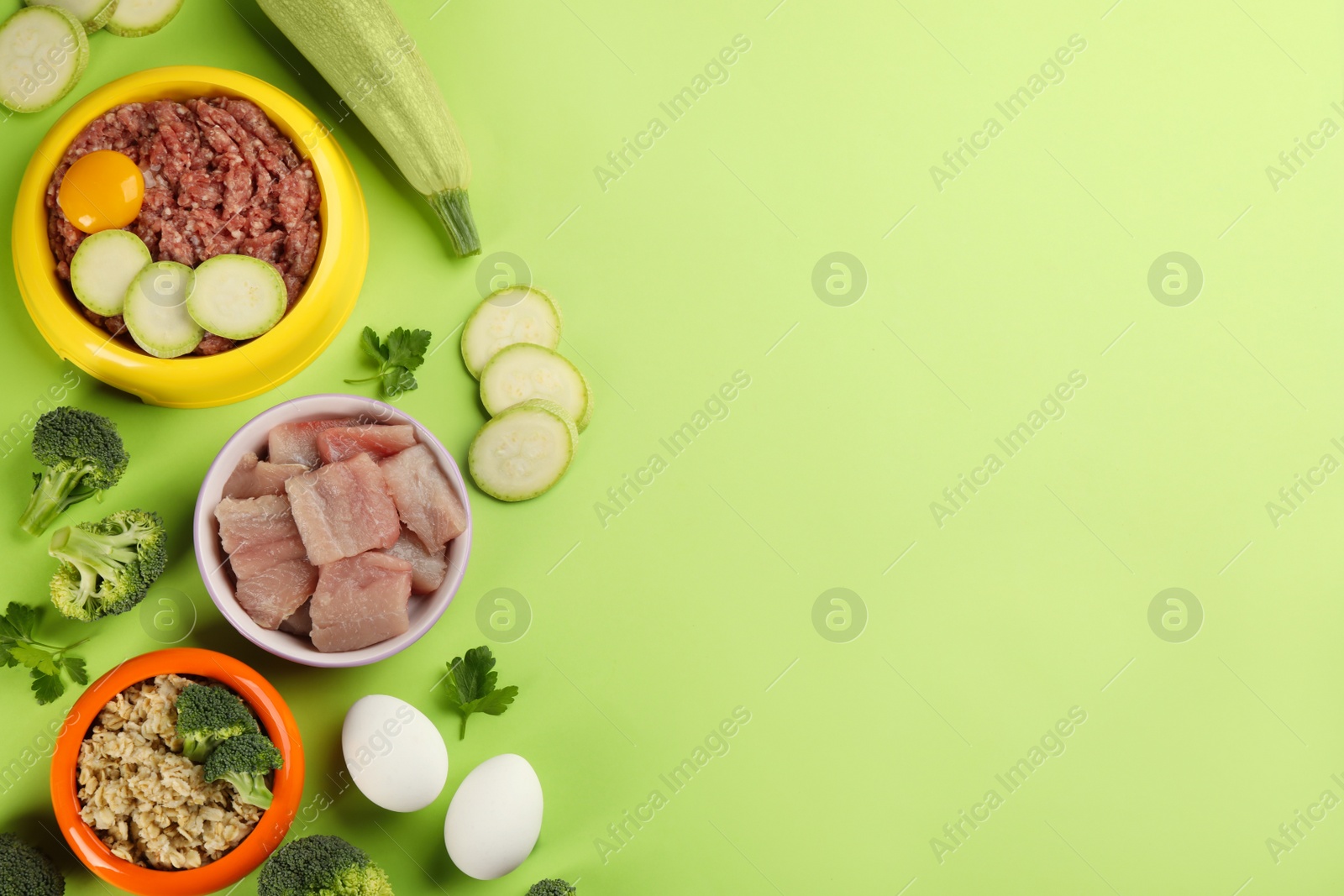 Photo of Pet food and natural ingredients on green background, flat lay. Space for text