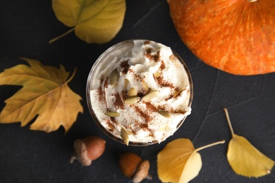 Photo of Flat lay composition with pumpkin spice latte in glass on dark background