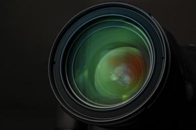Photo of Lens of professional camera on black background, closeup