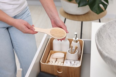 Bath accessories. Woman organizing personal care products indoors, closeup