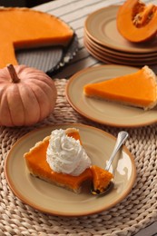 Photo of Fresh homemade pumpkin pie with whipped cream on table