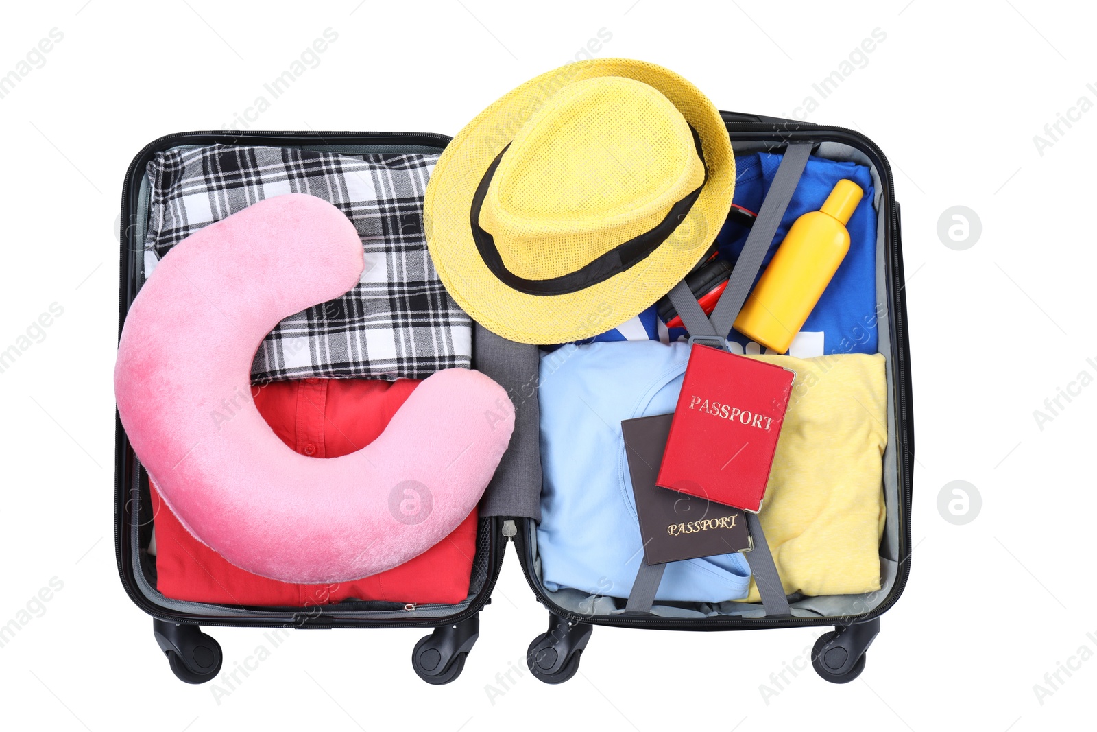 Photo of Soft travel pillow, hat, passports and other items in open suitcase isolated on white, top view