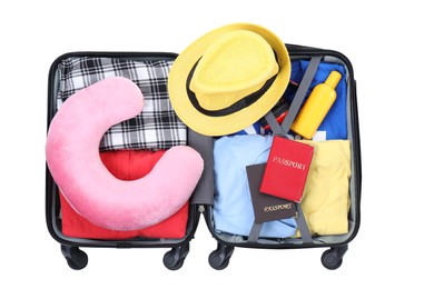 Photo of Soft travel pillow, hat, passports and other items in open suitcase isolated on white, top view