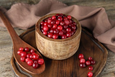 Photo of Cranberries in bowl and spoon on wooden table