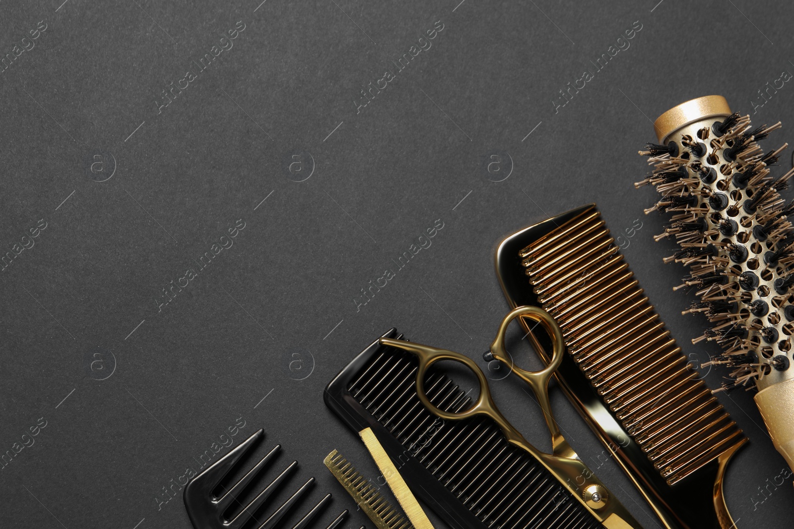 Photo of Hairdressing tools on dark table, flat lay. Space for text