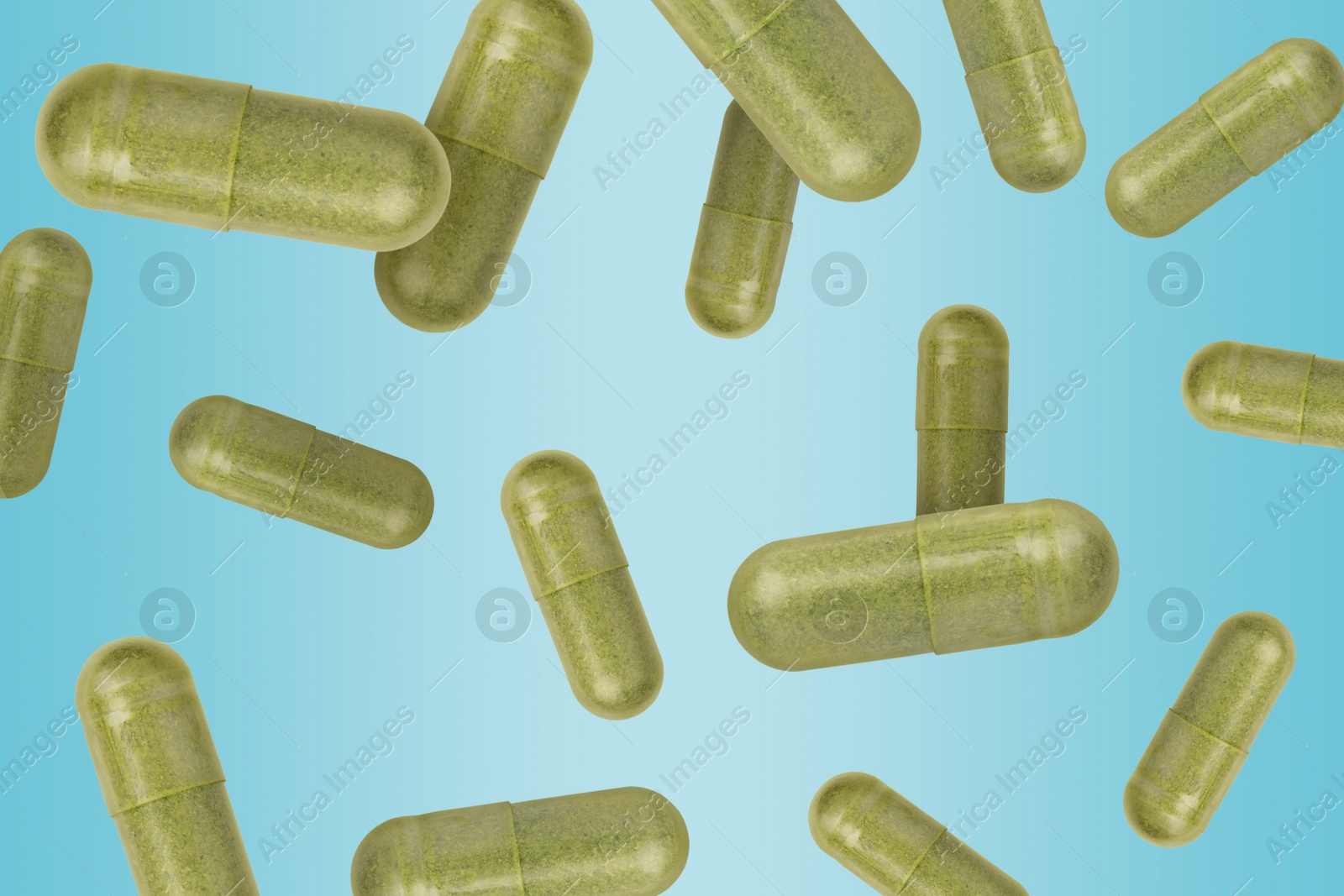 Image of Vitamin. Capsules falling on light blue gradient background