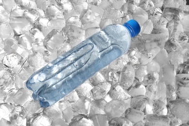 Photo of Bottle of water on pile of ice cubes