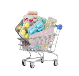 Photo of Blisters with different pills in mini shopping cart on white background