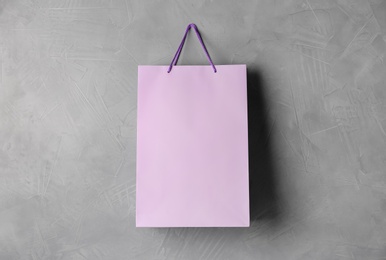 Paper shopping bag hanging on grey wall