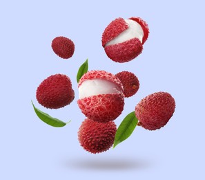 Image of Fresh lychees with green leaves falling on light blue background